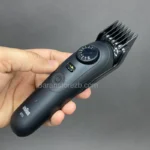 عکس از ماشین اصلاح براون مدل BT5560 با شانه درشت نصب شده روی آن در دست